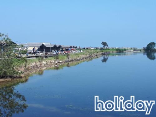 a view of a river with houses in the background at La cabane du littoral in La Teste-de-Buch