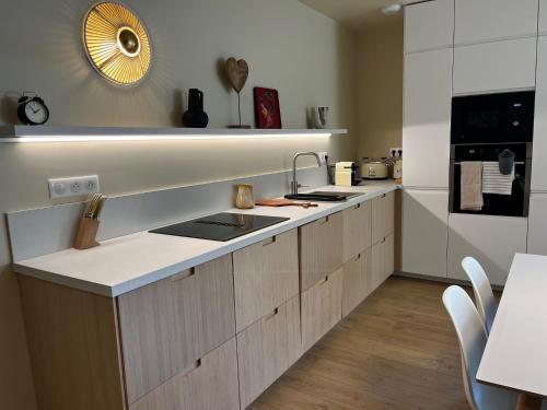 une cuisine avec un évier et un plan de travail dans l'établissement Maison de bord de mer, à Lion-sur-Mer