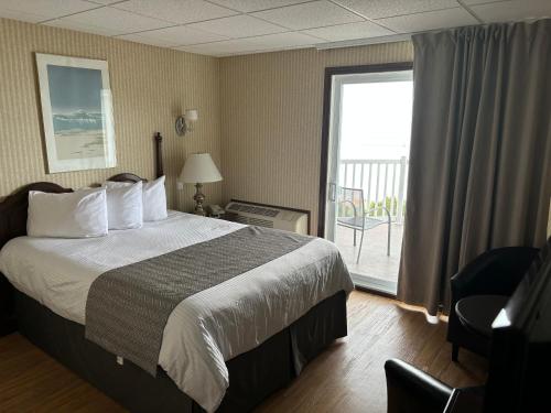 a hotel room with a bed and a balcony at Motel vue Belvédère in Saint-Siméon