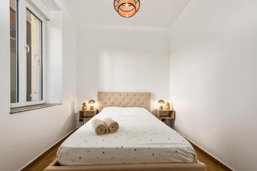 une chambre avec un lit avec deux serviettes dessus dans l'établissement LOGGIAS - Somptueux 4 pièces - Parking - Terrasse - Menton, à Menton