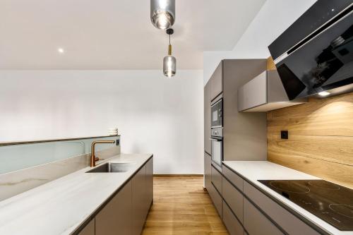 - une cuisine avec des comptoirs blancs et un évier dans l'établissement LOGGIAS - Somptueux 4 pièces - Parking - Terrasse - Menton, à Menton