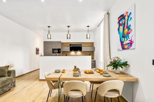 une salle à manger et une cuisine avec une table et des chaises dans l'établissement LOGGIAS - Somptueux 4 pièces - Parking - Terrasse - Menton, à Menton