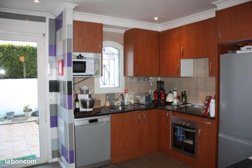 une cuisine avec des armoires en bois et un réfrigérateur blanc dans l'établissement Large Basque villa with garden near the beach, à Hendaye