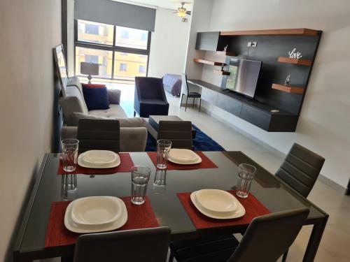 a dining room with a table and chairs and a living room at Depto en Barrio Antiguo, Santa Lucia y Fundidora in Monterrey