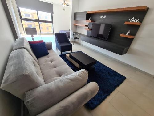 a living room with a couch and a tv at Depto en Barrio Antiguo, Santa Lucia y Fundidora in Monterrey
