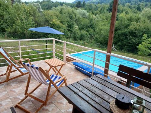 a patio with a table and chairs and a swimming pool at Vikendica Lep pogled in Rtanj