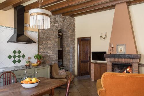 a kitchen with a table and a fireplace at Cal Carulla in L'Astor