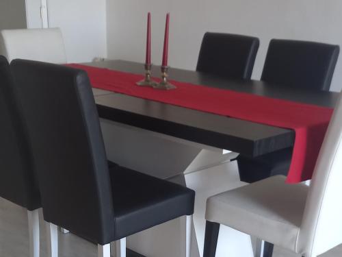a black table with black chairs and a red table at Vista para a serra in Bragança