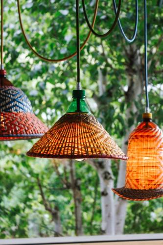 three lights hanging from a chain with trees in the background at SchönBerg hotel b&b in Rio Bianco