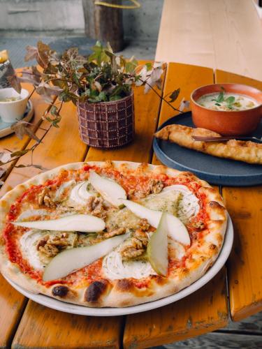 two pizzas on plates on a wooden table at SchönBerg hotel b&b in Rio Bianco