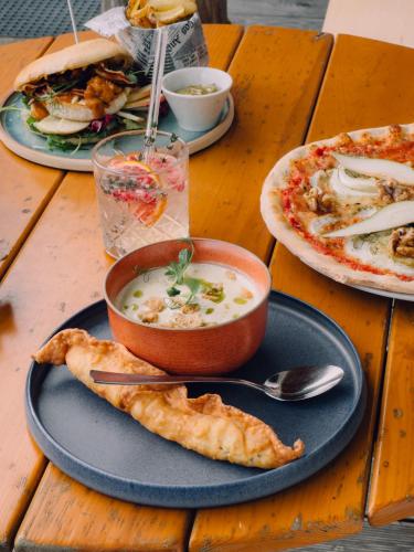a table with a bowl of soup and a plate of food at SchönBerg hotel b&b in Rio Bianco