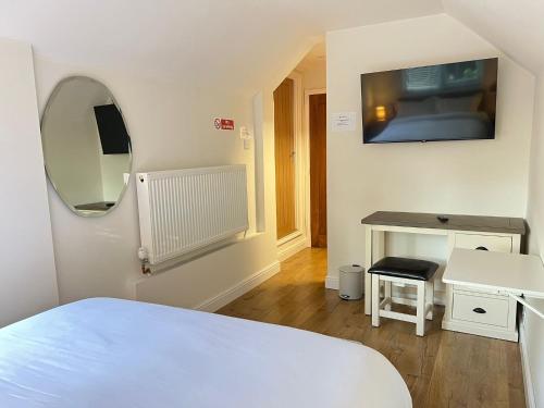 a bedroom with a bed and a mirror and a table at The Cosy Place near centre in Ipswich