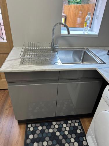 a kitchen counter with a sink and a keyboard on it at The Cosy Place near centre in Ipswich
