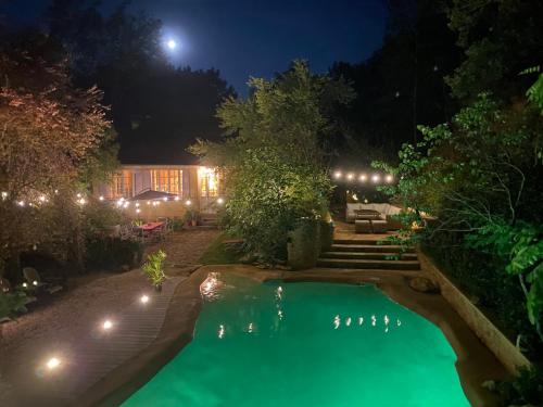 une piscine dans une cour la nuit dans l'établissement Le lagon des Naïades - Vallée des châteaux, à Daglan