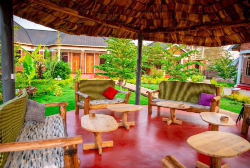 an outdoor patio with tables and chairs and an umbrella at Siafu Serenity Lodge in Mto wa Mbu