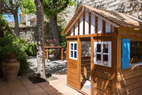 a wooden play house with a door in a yard at Cal Carulla in L'Astor