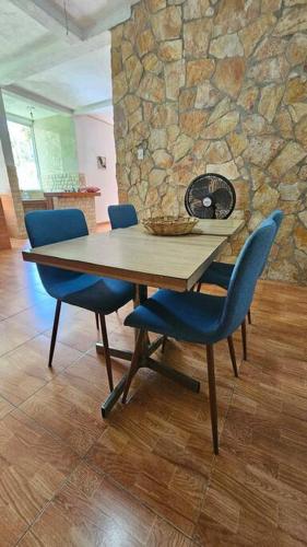 una mesa de madera con sillas azules y una pared de piedra en MODERN BEACH VILLA between La Punta & Zicatela, en Brisas de Zicatela
