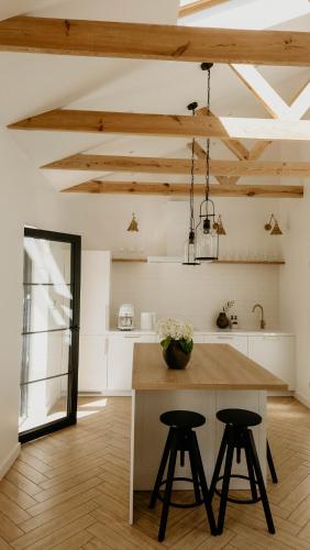 a kitchen with a table and two stools at Balia i Las Domek nad jeziorem MoreLife House in Tuczno