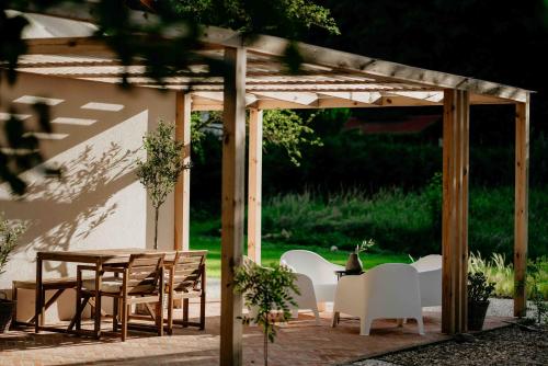 a wooden pergola with a table and chairs at Balia i Las Domek nad jeziorem MoreLife House in Tuczno