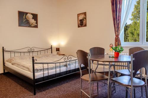 a bedroom with a bed and a table and chairs at Apartmany PAVILON D - Budget, Classic, Family - Novy Smokovec - High Tatras in Smokovce