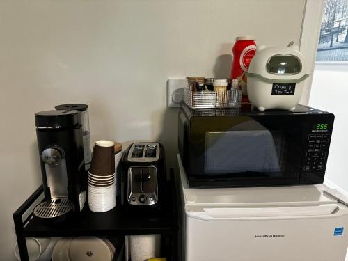 a microwave oven sitting on top of a refrigerator at Stay With Precious in Halifax