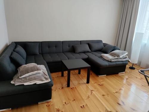 a living room with a black couch and a table at Located in Ances pagasts Apartments in Ance