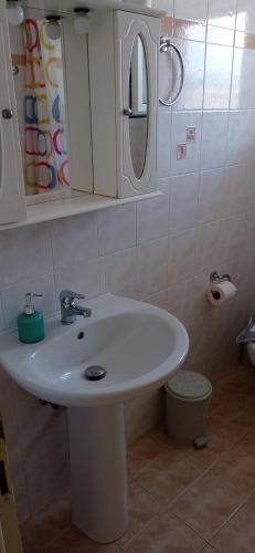 a bathroom with a white sink and a mirror at Sunny Beach Apartments in Rethymno Town