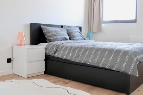 a bedroom with a bed and a white nightstand at Ghent Penthouse in Ghent
