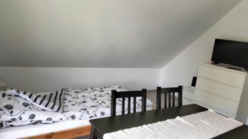 a bedroom with a bed and a tv and a table at Sielska Dolina pod Ślężą in Mysłaków