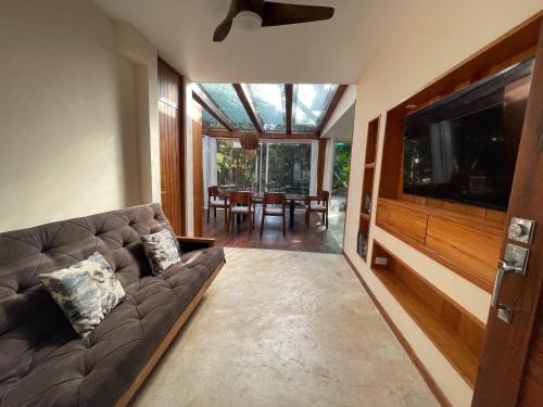 a living room with a couch and a flat screen tv at Villa Yaakun in Tulum