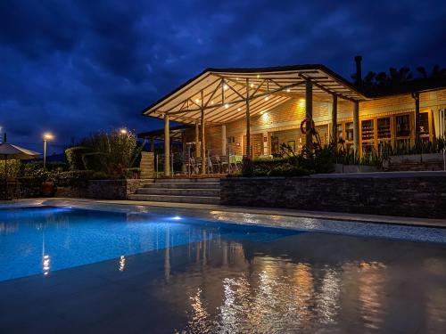 a house with a swimming pool at night at Finca del Café - Casa Typica in Santa Rosa de Cabal