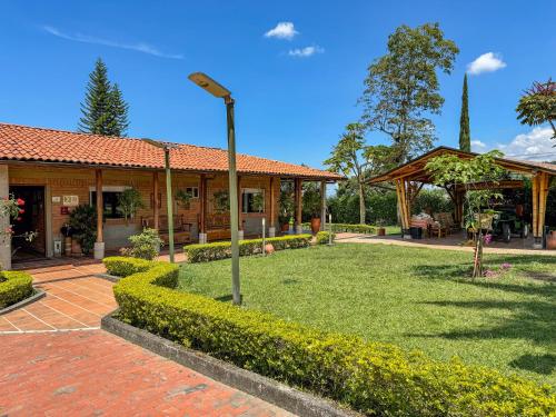 a house with a garden and a street light at Finca del Café - Casa Typica in Santa Rosa de Cabal