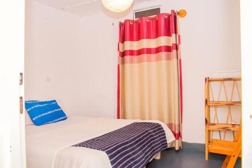 - une chambre avec un lit et un rideau dans l'établissement Eco Cottage BnB, à Ruhengeri