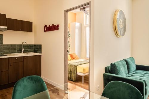 - un salon avec un canapé vert et un miroir dans l'établissement Appart BonaVita Narbona, à Narbonne