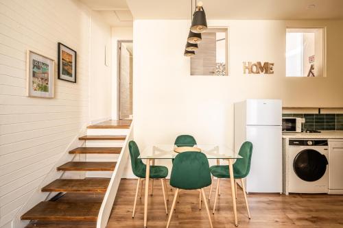 une salle à manger avec une table et des chaises vertes dans l'établissement Appart BonaVita Narbona, à Narbonne
