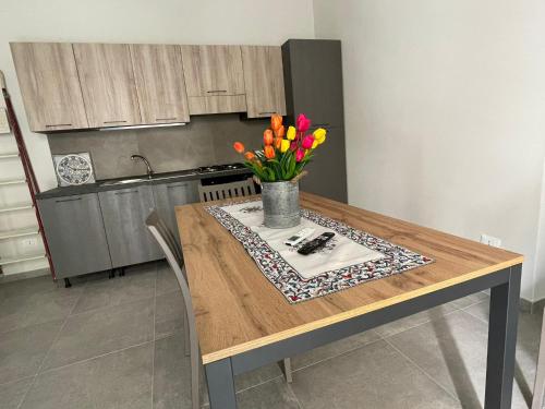 a kitchen table with a vase of flowers on it at Lazzara 19 in Marsala