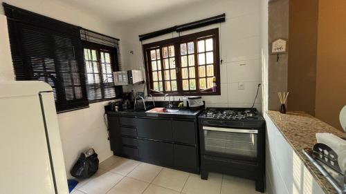 a kitchen with a stove and a sink at Chalé Benfica - Condominio Chales do Parque in Itatiaia