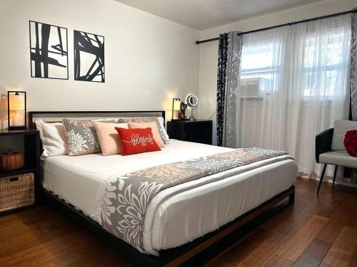 Un dormitorio con una cama con almohadas rojas y una ventana. en GSH202-Green Sweet Home-Disneyland and Little Saigon, en Westminster