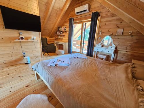 a bedroom with a bed in a wooden cabin at Holiday home LUNA in Donje Orešje