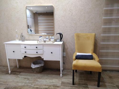 baño con lavabo, espejo y silla en Thornville Guest house Platinum, en Pietermaritzburg