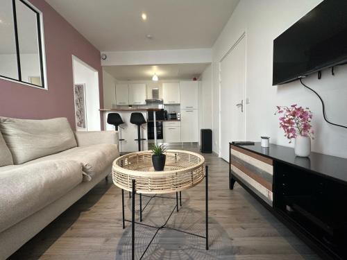 a living room with a couch and a table at Appartement Centre-ville 200m gare Vernon - proche Giverny in Vernon