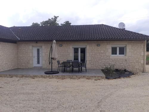 une maison avec un patio avec une table et un parasol dans l'établissement Maison dans le Périgord, à Saint-Cernin-de-lʼHerm