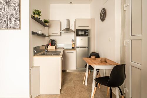 une petite cuisine avec une table et des chaises en bois dans l'établissement Studio Hélios Narbona, à Narbonne