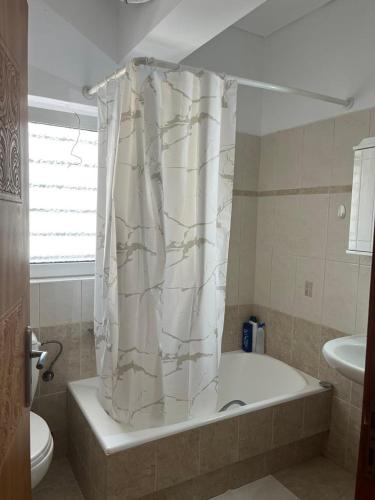 a bathroom with a tub and a shower curtain at Peter appartments in Vrachati