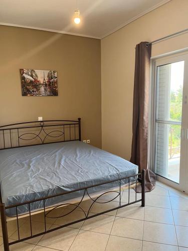 a bedroom with a bed and a large window at Peter appartments in Vrachati