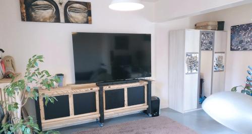 a living room with a large flat screen tv at LIKE HOME - Comme Chez Soi - Chambre d'hôte in Saint Lo