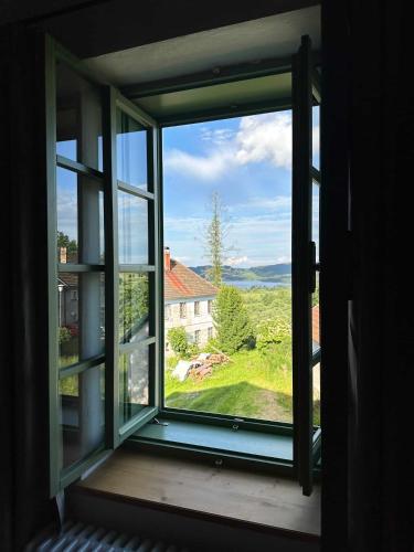 an open window with a view of a house at Apartmány Hodňov 17 in Horní Planá
