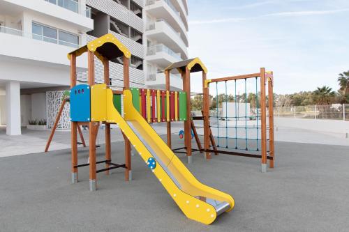 ein Spielplatz mit Rutsche vor einem Gebäude in der Unterkunft Gran Canet Vlado in Canet d'en Berenguer