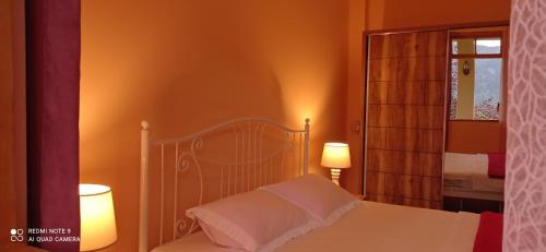 una camera da letto con un letto bianco con due lampade di GUEST HOUSE RIMAS HOME a Khulo