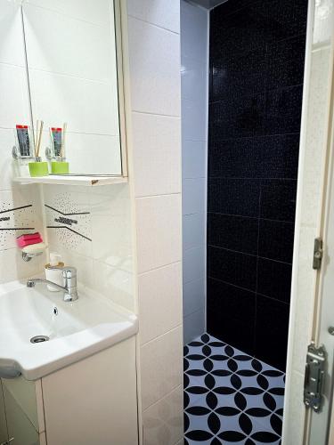 a bathroom with a sink and a shower at Garsoniera Aleea Trandafirilor in Băile Herculane